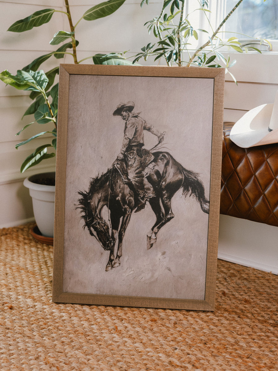 Pecos Will framed western art leaning in a living room