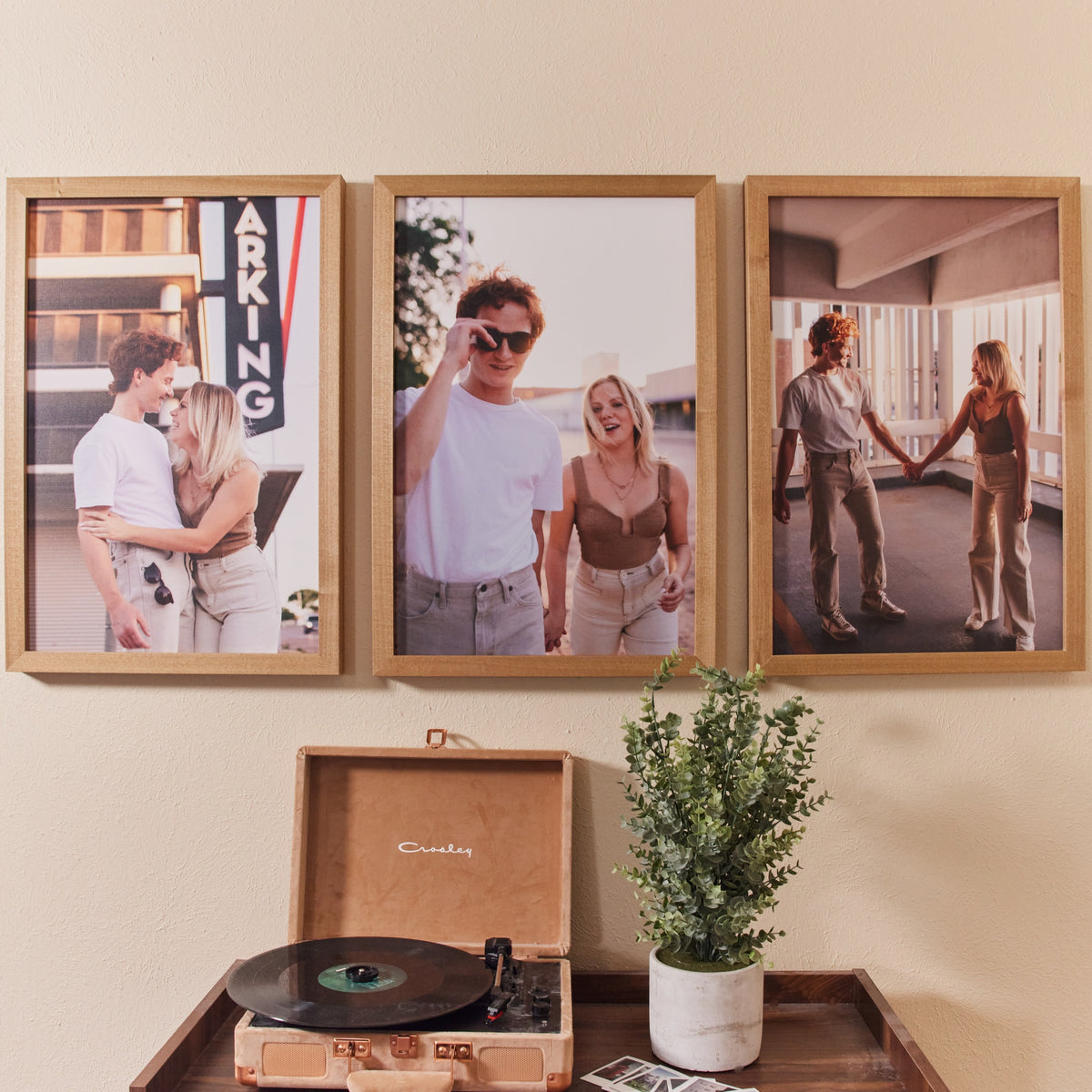 Three large framed couple photos above a record player