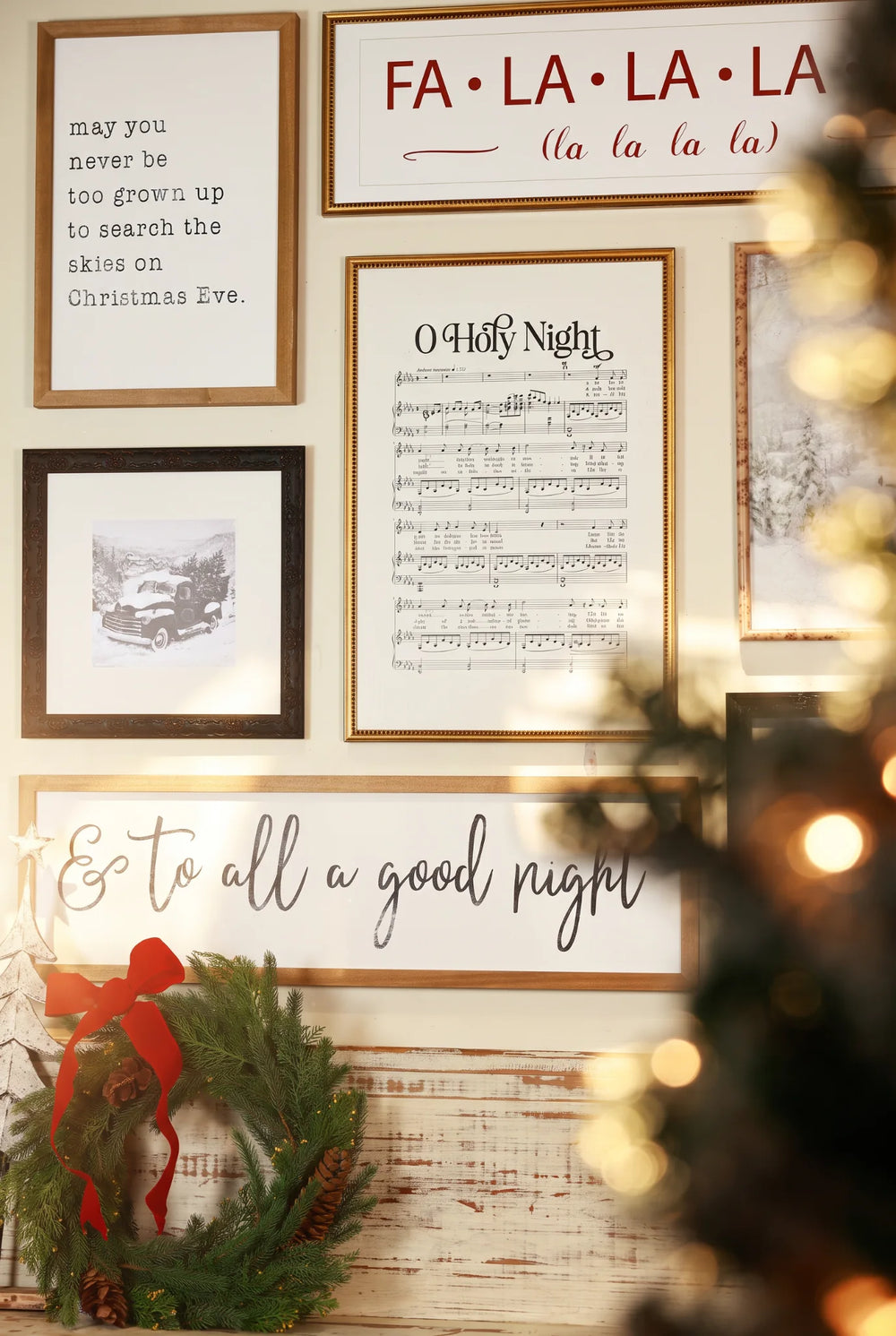 Christmas gallery wall with O Holy Night sheet music, festive framed art, and a wreath